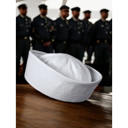 bob marin US Navy blanc posé sur table, équipage en arrière-plan flou